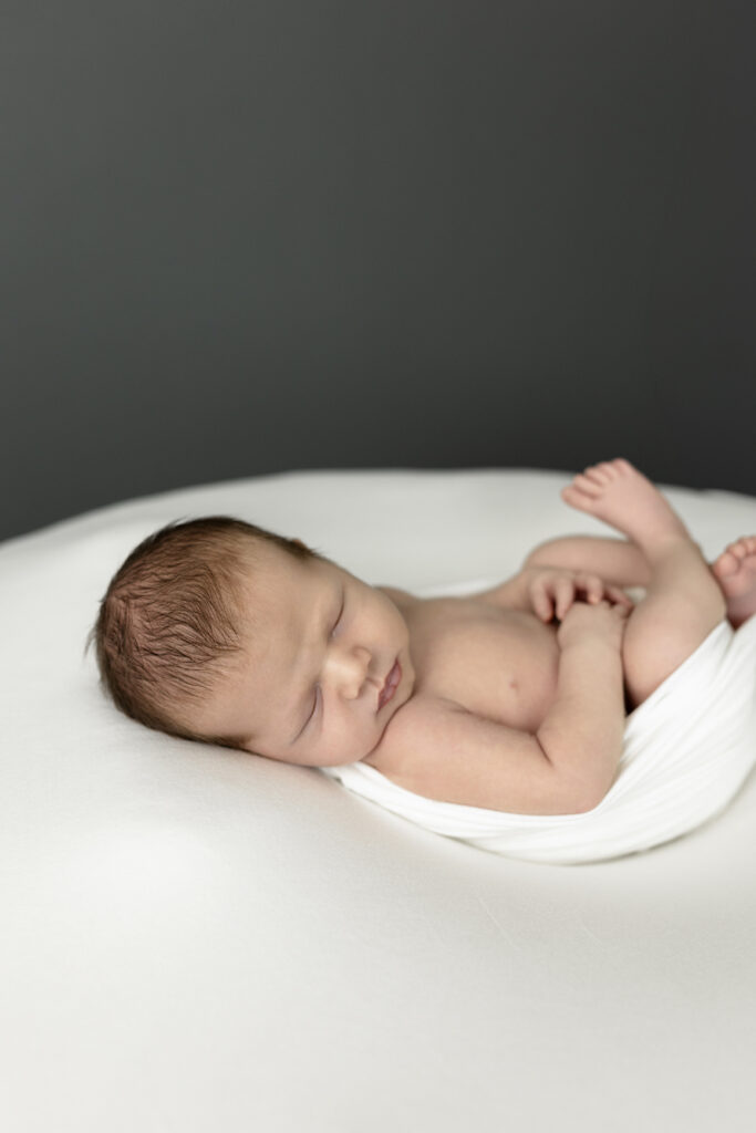 Newborn baby asleep in white