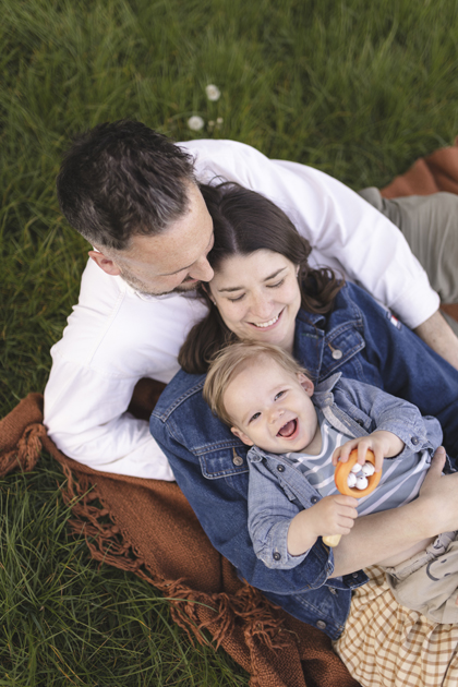 Family cuddling together during an outdoor family photoshoot in Surrey by Abigail Evans Photography.